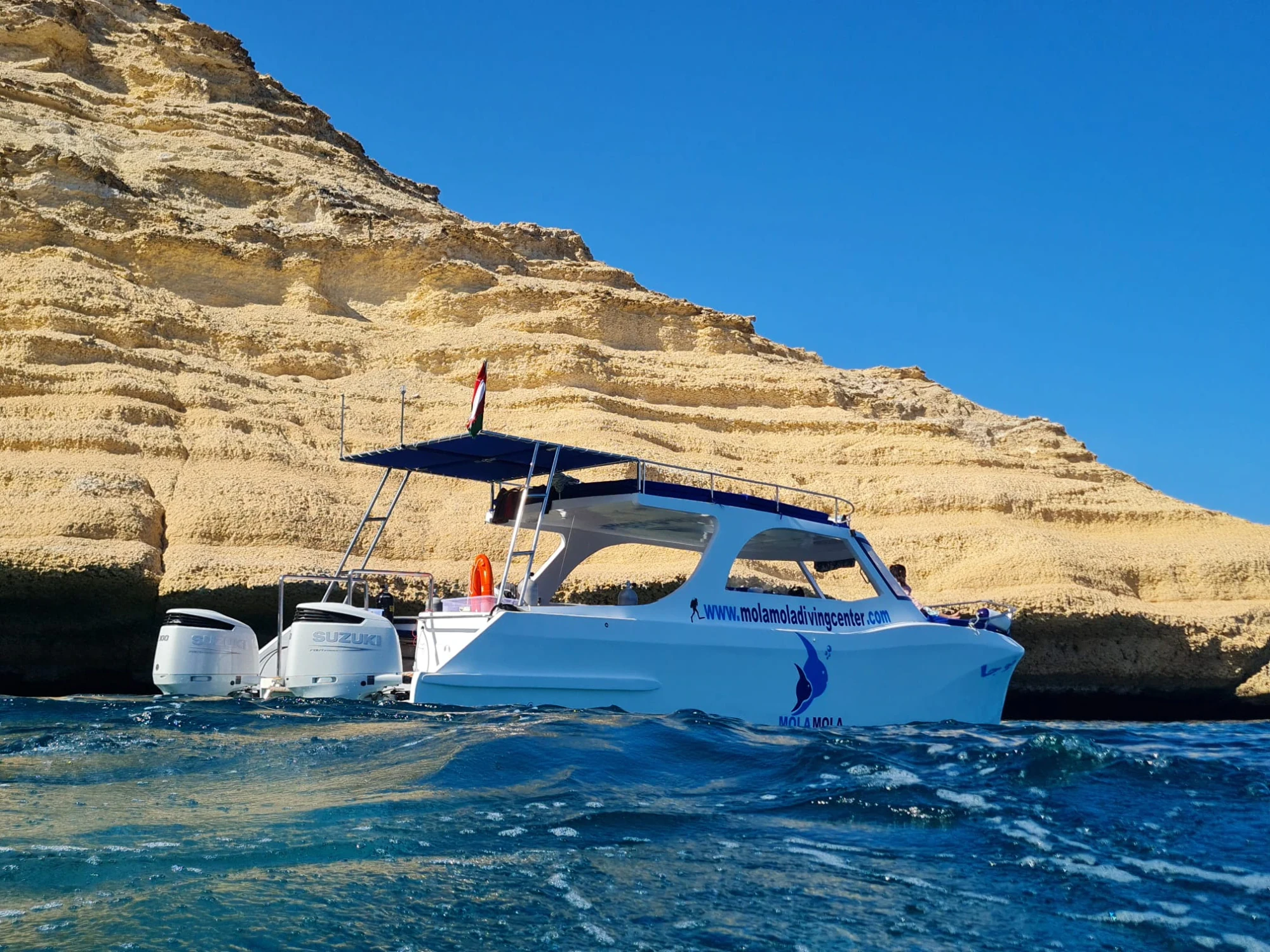 MolaMola dive boat beside the cliffs of the Daymaniyat Islands