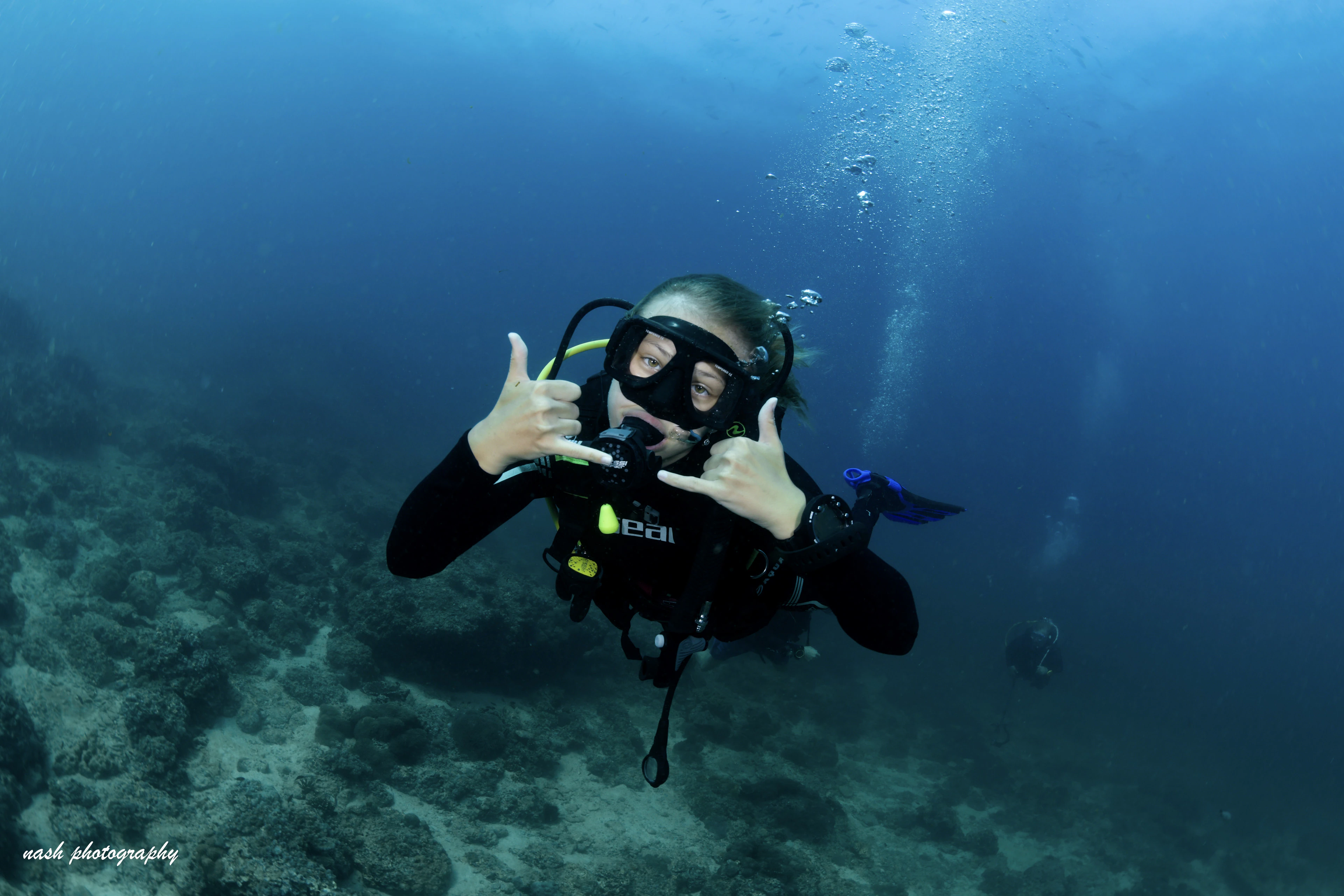 Smiling new diver giving a shaka sign