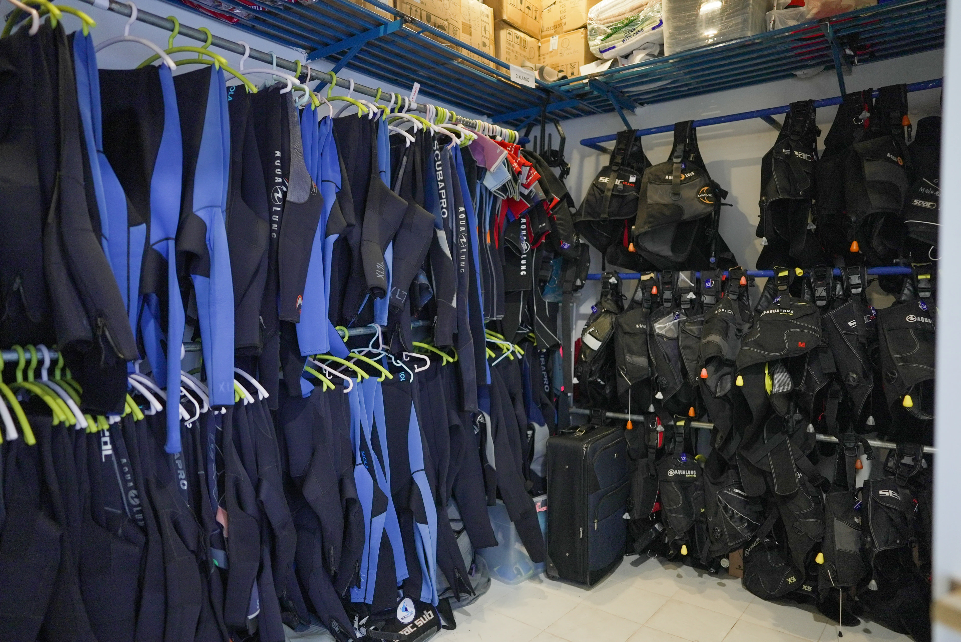 Rental wetsuits and BCDs ready in the gear room