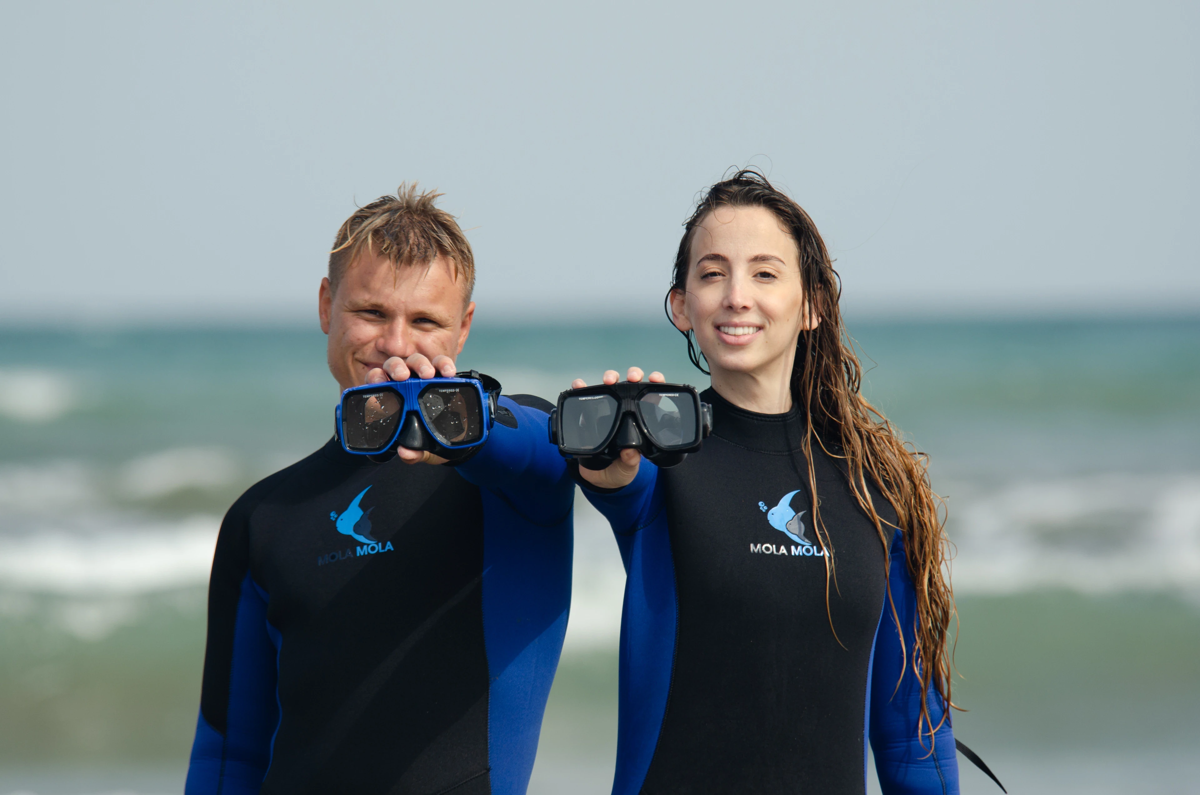 MolaMola divers holding their masks on the beach