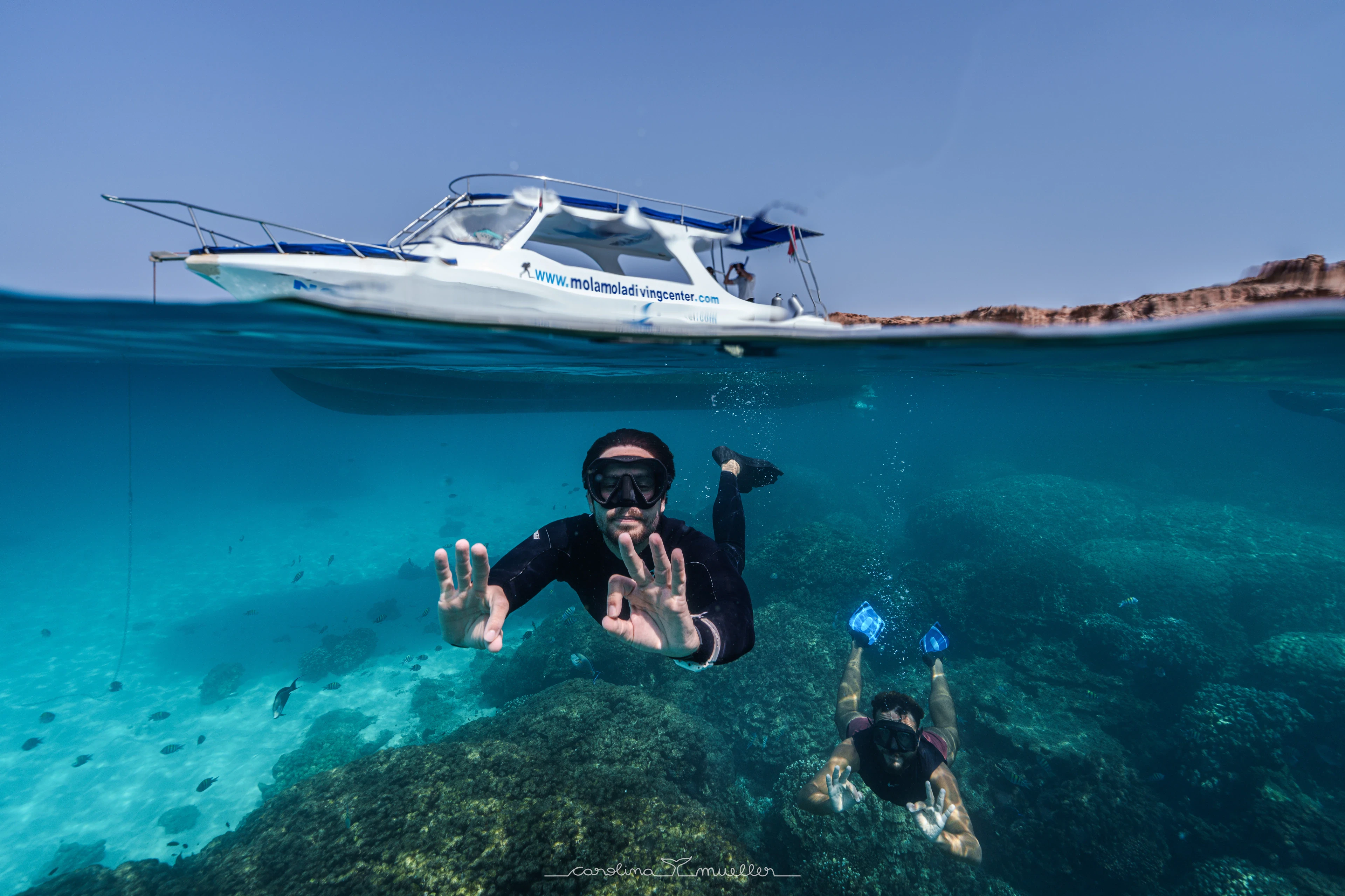 Snorkelers waving under the MolaMola boat
