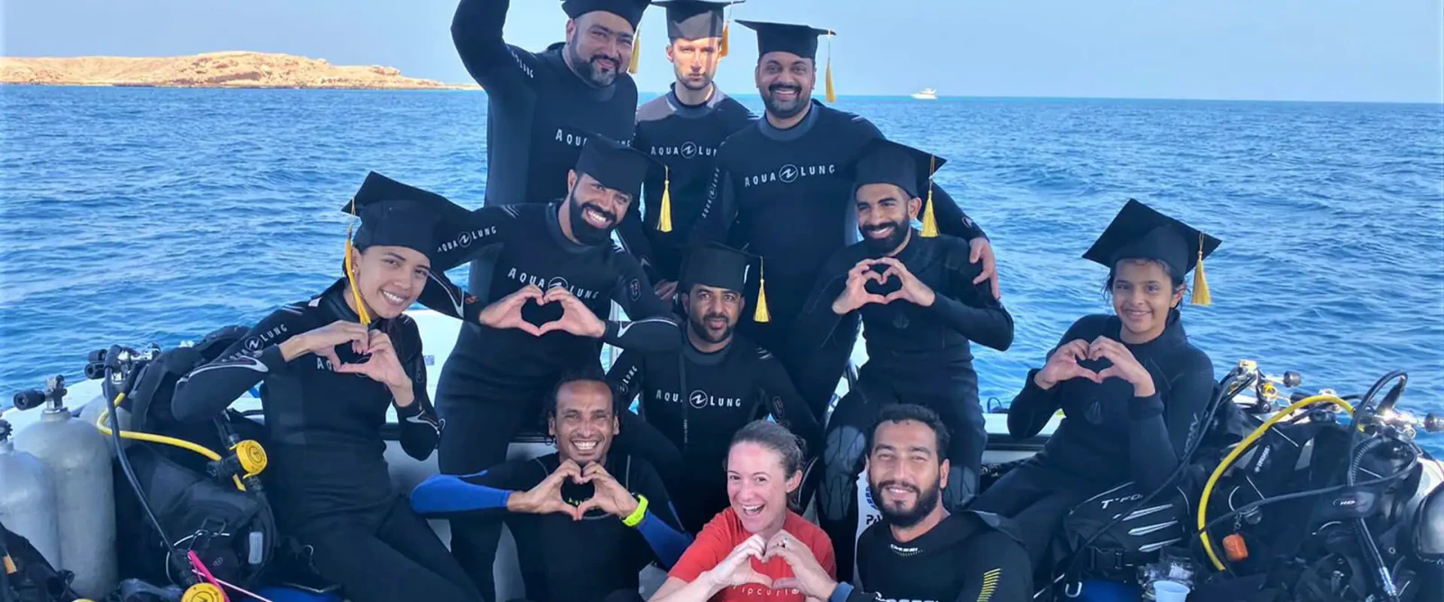 New Open Water divers celebrating their certification on the boat