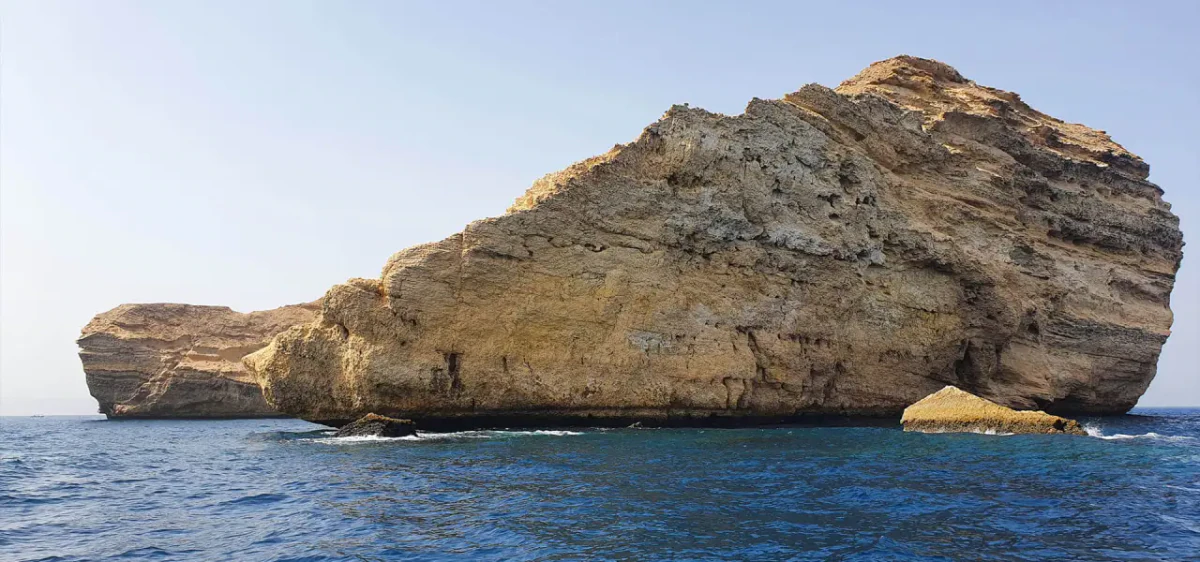 Limestone cliffs of Fahal Island rising from the sea